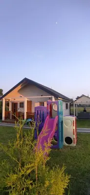 a group of play equipment in the grass in front of a house at Domki Magnolia Noclegi & SPA Zator in Zator