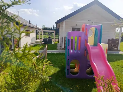 a plastic play structure in the yard of a house at Domki Magnolia Noclegi & SPA Zator in Zator