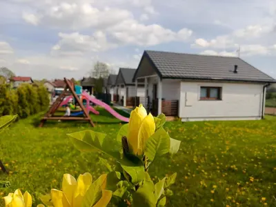 a view of a playground with a house and a park at Domki Magnolia Noclegi & SPA Zator in Zator