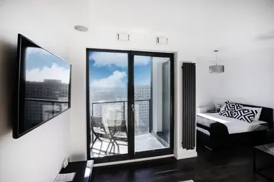 a bedroom with a bed and a large window at Apartamenty Platinex in Kraków