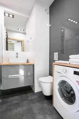 a bathroom with a washing machine and a toilet at Apartamenty Platinex in Kraków
