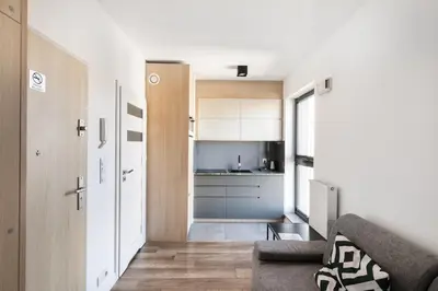 a living room with a couch and a kitchen at Apartamenty Platinex in Kraków