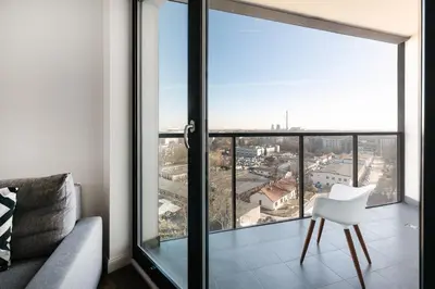 a living room with a large window with a white chair at Apartamenty Platinex in Kraków