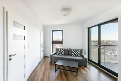 a living room with a couch and large windows at Apartamenty Platinex in Kraków