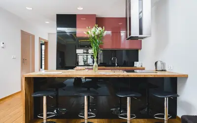a kitchen with a large island with black bar stools at Glam Brewery Suite - Deluxe Apartment with Parking - by Upstairs in Kraków