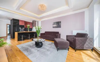 a living room with two chairs and a couch at Glam Brewery Suite - Deluxe Apartment with Parking - by Upstairs in Kraków