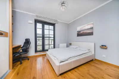 a bedroom with a bed and a desk and a window at Glam Brewery Suite - Deluxe Apartment with Parking - by Upstairs in Kraków