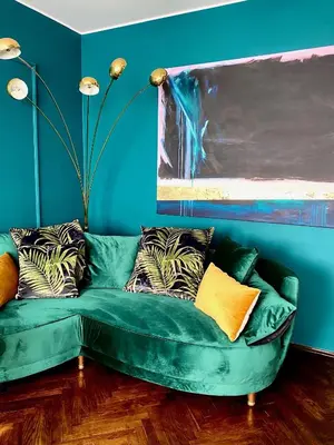 a green couch in a living room with blue walls at DREAM Boutique Apartment 42m2 in the heart of Cracow Old Town in Kraków