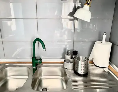 a kitchen sink with a green kitchen faucet at DREAM Boutique Apartment 42m2 in the heart of Cracow Old Town in Kraków