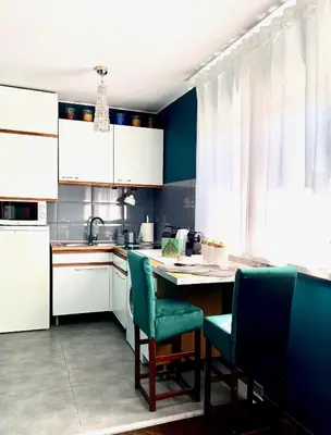 a kitchen with white cabinets and a table and chairs at DREAM Boutique Apartment 42m2 in the heart of Cracow Old Town in Kraków