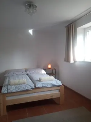 a bed in a white room with a window at Agroturystyka u Babci in Czchów