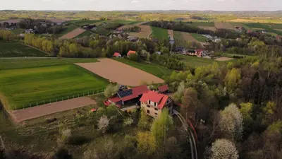 a house with a red roof in a field at Agroturystyka u Babci in Czchów