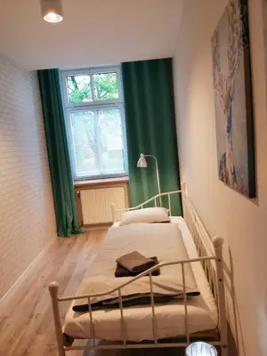 a bedroom with two beds with green curtains and a window at Apartament Galicja Plus in Chrzanów