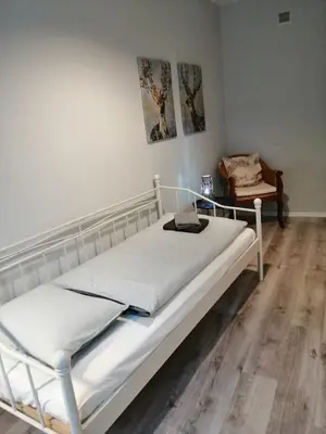 a white bed in a room with a wooden floor at Apartament Galicja Plus in Chrzanów
