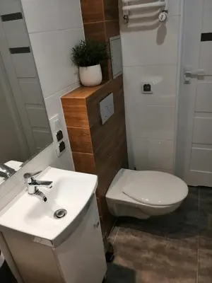 a bathroom with a white toilet and a sink at Apartament Galicja Plus in Chrzanów
