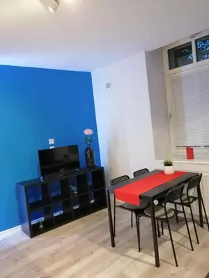 a dining room with a red table and chairs at Apartament Galicja Plus in Chrzanów