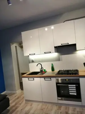 a kitchen with white cabinets and a sink and a stove at Apartament Galicja Plus in Chrzanów