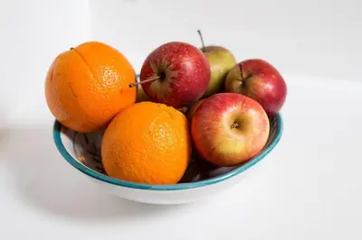 a bowl of oranges and apples on a table at Bright loft in amazing location in Kraków