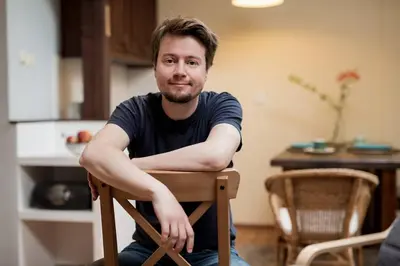 a man sitting in a chair with his arms crossed at Bright loft in amazing location in Kraków