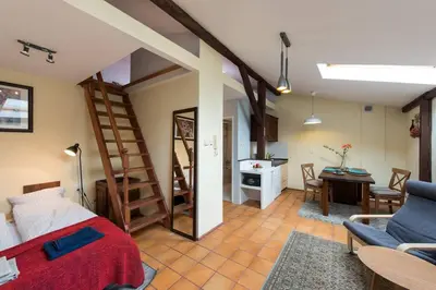 a living room with a bed and a dining room at Bright loft in amazing location in Kraków