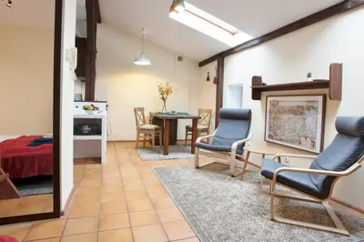 a living room with a table and chairs in a room at Bright loft in amazing location in Kraków