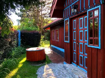 a red building with a tub in the yard at Secret Garden Residence in Paszkówka