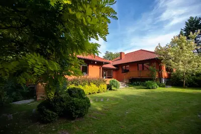 a house with a yard in front of it at Secret Garden Residence in Paszkówka
