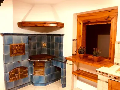 a kitchen with blue tiles on the wall and a counter at Secret Garden Residence in Paszkówka
