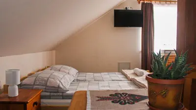 a bedroom with two beds and a desk and a table at Gorczański Kącik in Ochotnica Dolna