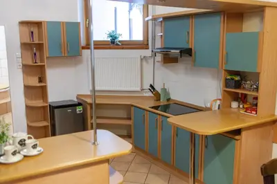 a small kitchen with blue cabinets and a sink at Bailey Apartment in Kraków
