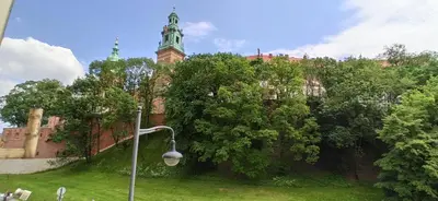 a street light in front of a building with a clock tower at Bailey Apartment in Kraków
