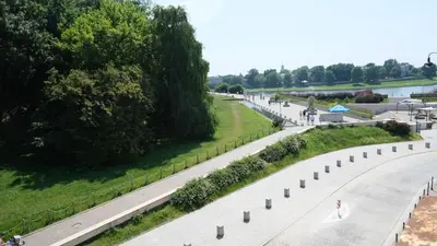 an empty street with trees and a road at Bailey Apartment in Kraków