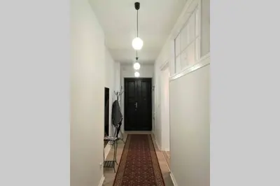 a hallway with white walls and a black door at Apartament Barbara - przy rynku in Wadowice