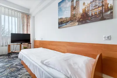 a bedroom with a bed and a flat screen tv at Hotel Biała Gwiazda in Kraków