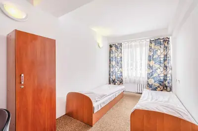 a small room with two beds and a window at Hotel Biała Gwiazda in Kraków