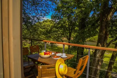 a living room with a couch and a table at Apartamenty wśród drzew River Park Zator SPA JACUZZI in Zator