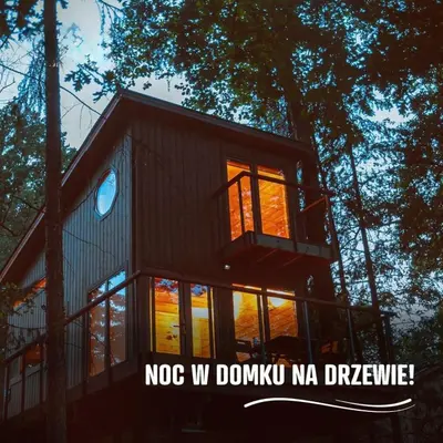 a woman sitting at a table with a cup of coffee at Apartamenty wśród drzew River Park Zator SPA JACUZZI in Zator