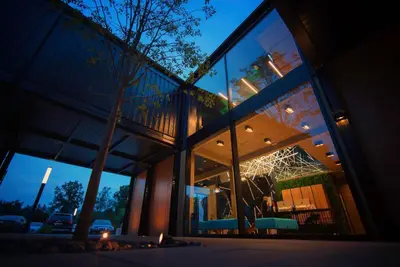 a building with large glass windows at night at Scandinavia Zator, an Ascend Collection Resort in Zator