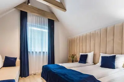 a bedroom with a large bed with a blue blanket at Scandinavia Zator, an Ascend Collection Resort in Zator