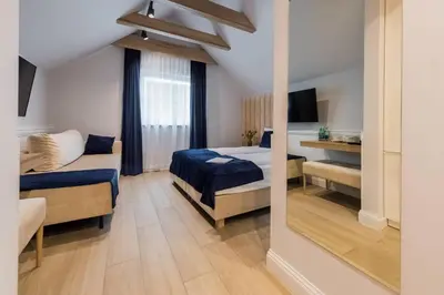 a bedroom with two beds and a large window at Scandinavia Zator, an Ascend Collection Resort in Zator