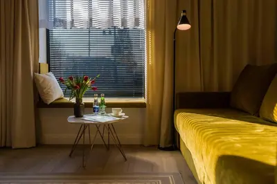 a living room with a couch and a table with flowers at Scandinavia Zator, an Ascend Collection Resort in Zator