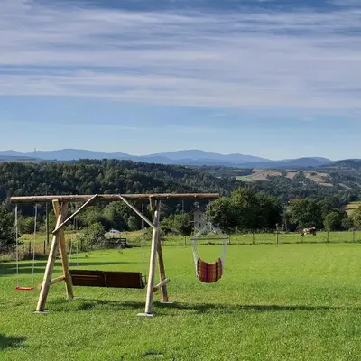 a swing set in the middle of a field at Barwald Hills - jacuzzi i piękny widok na Babią Górę i Beskidy in Wadowice
