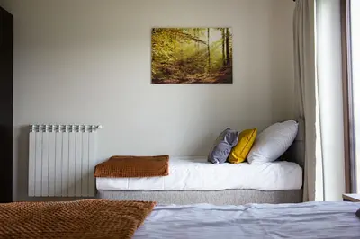 a bedroom with a bed and a picture on the wall at Barwald Hills - jacuzzi i piękny widok na Babią Górę i Beskidy in Wadowice