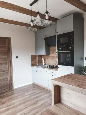 a kitchen with white cabinets and a wooden counter top at Jaszczurowa Apartament in Jaszczurowa