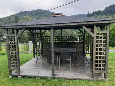 a wooden gazebo with a table and chairs at Jaszczurowa Apartament in Jaszczurowa