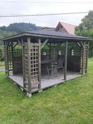 a wooden gazebo with a table and chairs at Jaszczurowa Apartament in Jaszczurowa