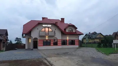 a house with a red roof with a garage at Noclegi Damianek in Nowy Targ