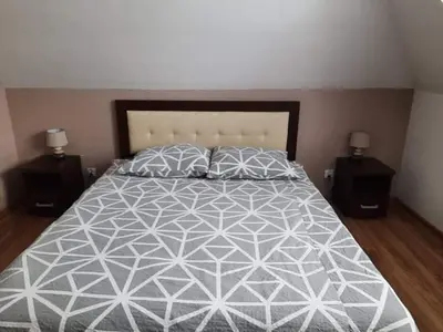 a bedroom with a large bed with two night stands at Noclegi Damianek in Nowy Targ
