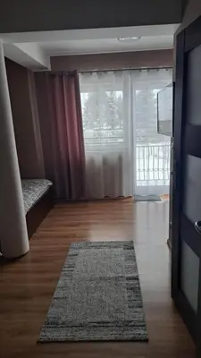 a living room with a large window and a rug at Noclegi Damianek in Nowy Targ