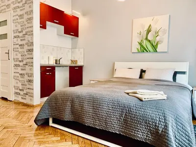 a bedroom with a bed and a kitchen at Studio in Center in Kraków